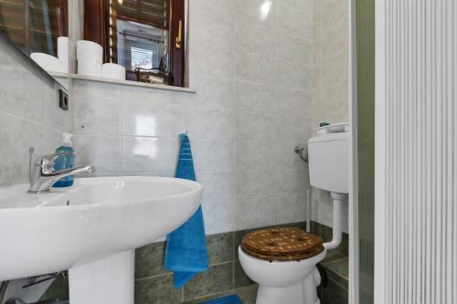 uma casa de banho com um lavatório branco e um WC. em Room 79-7 em Duće
