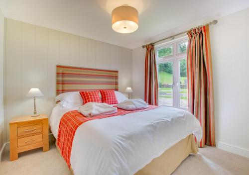 a bedroom with a large bed and a window at Llyn Dinas Lodge in Betws-y-coed