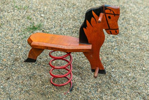 a wooden horse toy sitting on the ground at Penzion La Piccolina in Nový Bor