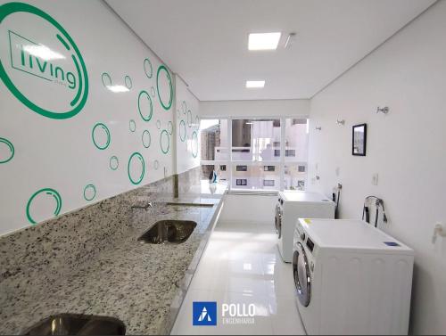 La salle de bains est pourvue d'un lavabo et d'un lave-linge. dans l'établissement Cosy Apartment in Fantastic Location in City Center, à Poços de Caldas