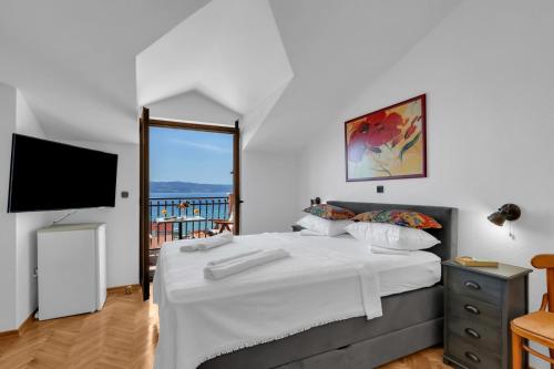 a bedroom with a bed and a flat screen tv at Room 79-8 in Duće