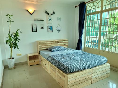 a bedroom with a bed and a large window at Yana House Phnom Penh in Phnom Penh