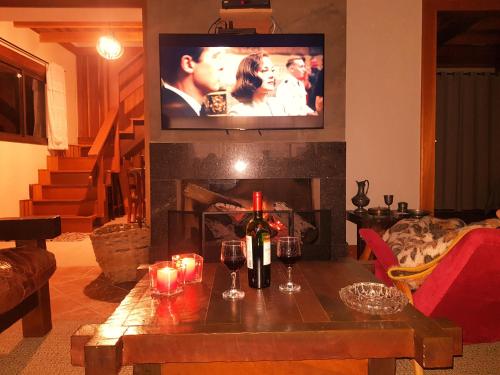 uma sala de estar com lareira e uma televisão por cima em Cabana Rústica - Sitio Kayalami em Tijucas do Sul