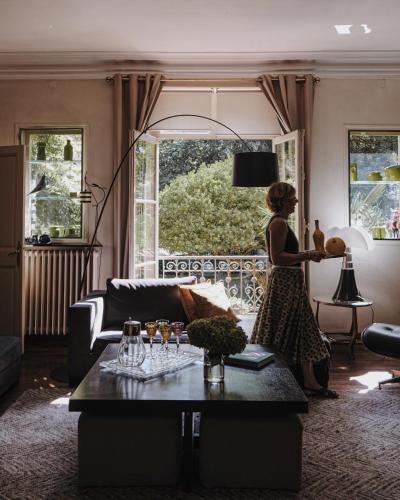 a woman standing in a living room looking out a window at Castel Jolly in Rennes