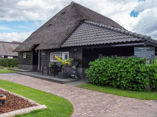 a small black house with a thatched roof at De Sloothaak in Giethoorn
