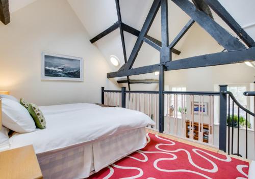a bedroom with a large bed and a balcony at Lletyr Plas in Llanbedrog
