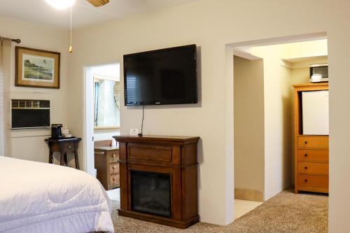 1 dormitorio con TV de pantalla plana en la pared en The Bonnie Inn Unit 5 with Breakfast Nook, en San Andreas