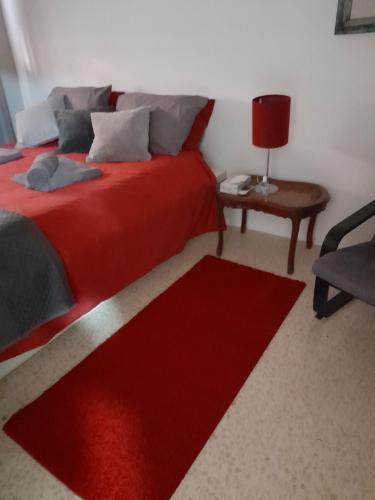 a bedroom with a red bed and a red rug at Gozo Marsalforn in Marsalforn