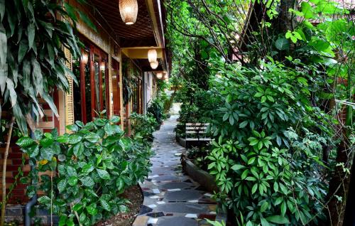 a garden path with plants on the side of a building at Tam Coc Amanda Villas in Ninh Binh