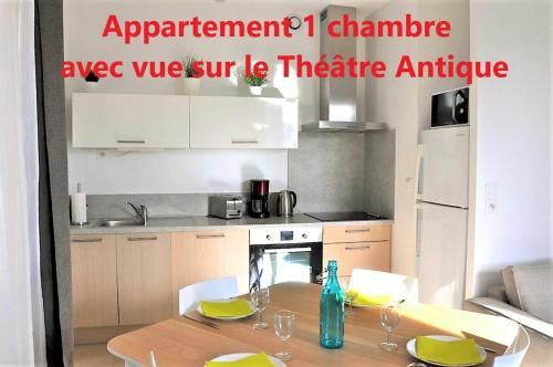 a kitchen with a table with chairs and a dining room at Holiday in Arles -Appartement du Théâtre Antique in Arles