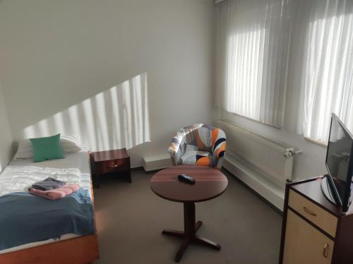 a bedroom with a bed and a chair and a table at Zimmer am Jüdenhof in Heilbad Heiligenstadt