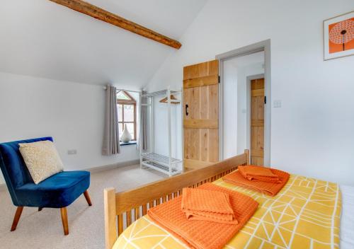 1 dormitorio con 1 cama y 1 silla azul en Cwt y Bugail, en Pentraeth