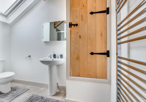 a bathroom with a white toilet and a sink at Cwt y Bugail in Pentraeth