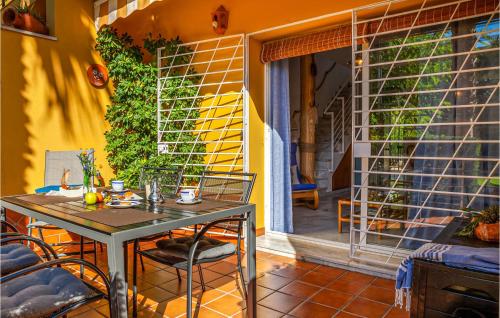 a table and chairs on a patio with a window at 2 Bedroom Amazing Home In Isla Cristina in Isla Cristina