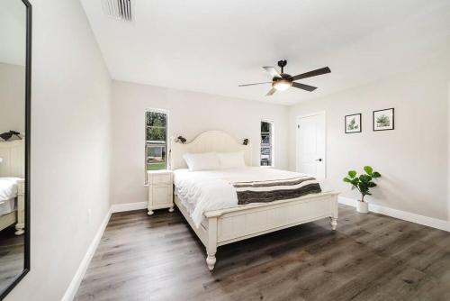 a white bedroom with a bed and a ceiling fan at New 6min to 3 Sister Springs, Spacious, Fun with Game Room in Crystal River