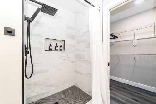 a bathroom with a shower with white tiles at New 6min to 3 Sister Springs, Spacious, Fun with Game Room in Crystal River