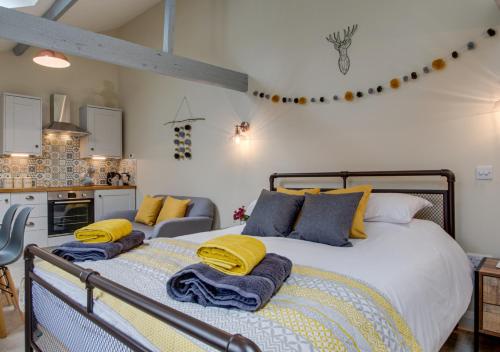 a bedroom with a large bed with yellow and blue pillows at Cwt Bach in Llanfair Talhaiarn