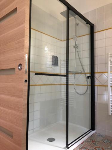 une douche avec une porte vitrée dans une salle de bain dans l'établissement Le Nid des Corbières, à Bizanet