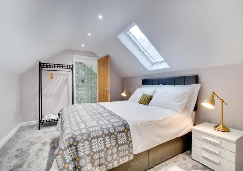 ein Schlafzimmer mit einem großen Bett und einem Dachfenster in der Unterkunft Cwrt y Llyn in Pen-y-groes