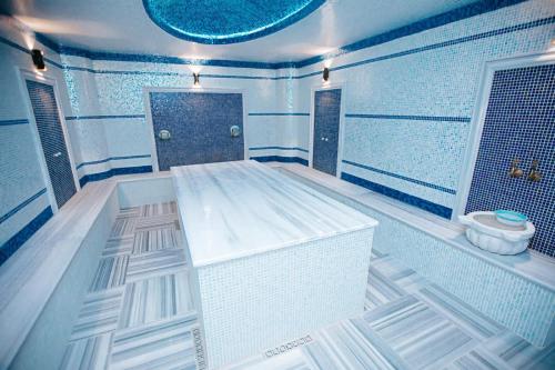 ein großes Bad mit einer Badewanne und einer Dusche in der Unterkunft Castle Resort Spa Hotel in İsmayıllı