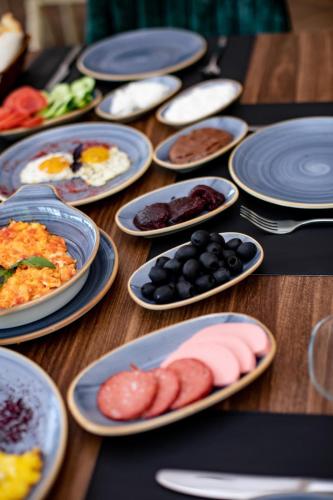 een houten tafel met borden met eten erop bij Castle Resort Spa Hotel in İsmayıllı