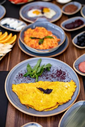 een tafel vol borden met eten, waaronder een omelet bij Castle Resort Spa Hotel in İsmayıllı