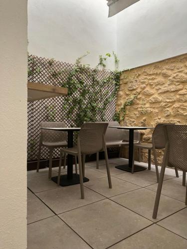 a table and chairs in a room with a stone wall at Enmathi Alicante Benalua in Alicante