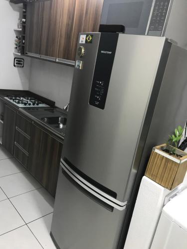 um frigorífico de aço inoxidável numa cozinha em Apartamento encantador em bairro Nobre. em Santa Cruz do Sul