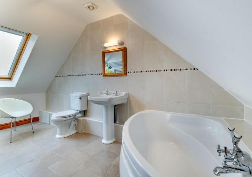 een badkamer met een wastafel, een bad en een toilet bij Nant y Llyn in Bala