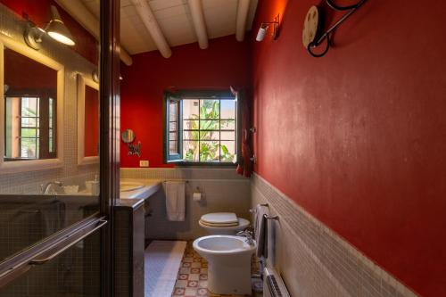 ein rotes Badezimmer mit WC und Waschbecken in der Unterkunft Covo D amuri in Erice