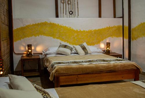 a bedroom with a large bed with two lamps at Refugio del Jaguar in Medellín