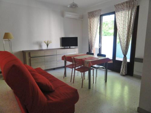 een woonkamer met een rode bank en een tafel bij Chez Mi, centre ville, parking gratuit, arrivée autonome in Saint-Chinian