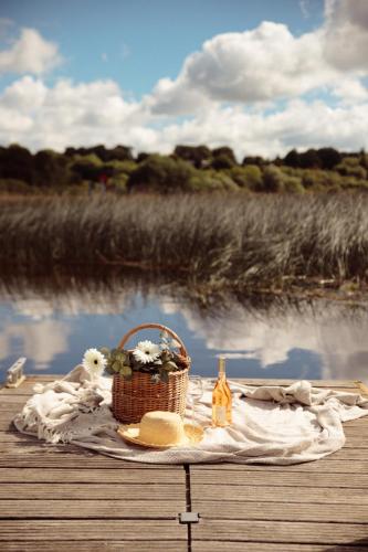 a picnic table with a basket of flowers and a wine bottle at Glasson Lakehouse in Athlone