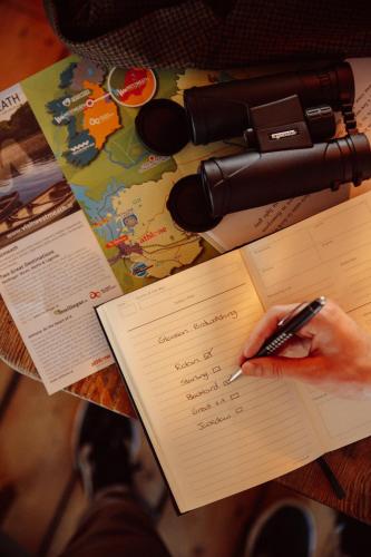 a person holding a pen in a book on a table at Glasson Lakehouse in Athlone