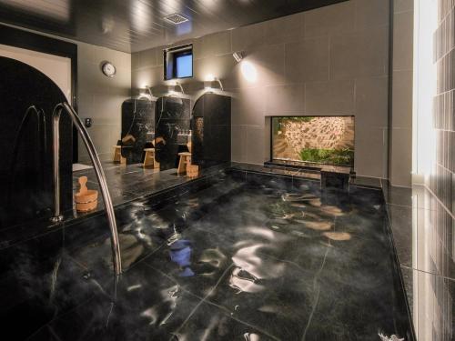 東京的住宿－Super Hotel Premier Ikebukuro Natural Hot Spring，一间带水景浴缸的浴室