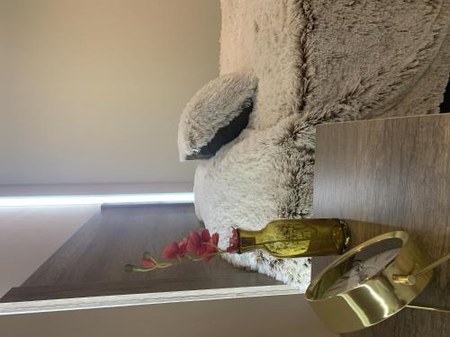 a bottle of wine and a flower on a shelf at LA GRANDE MAISON in Aguascalientes