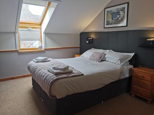 a bedroom with a bed with two towels on it at Murray Arms Hotel and Seafood Restaurant, Orkney in Saint Margarets Hope