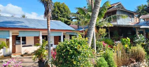 a house with palm trees and flowers at Beach Guest House in Maninjau