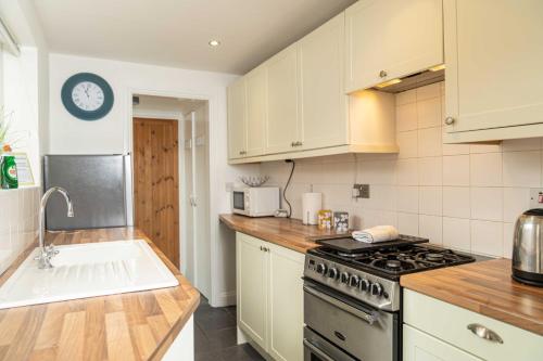 a kitchen with white cabinets and a stove top oven at East Street, Town Centre, 2 Bedrooms in Tewkesbury
