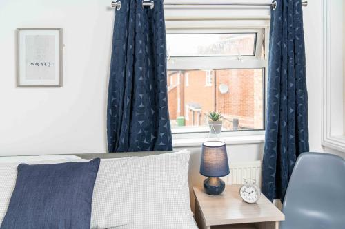 a bedroom with a bed and a window with curtains at East Street, Town Centre, 2 Bedrooms in Tewkesbury