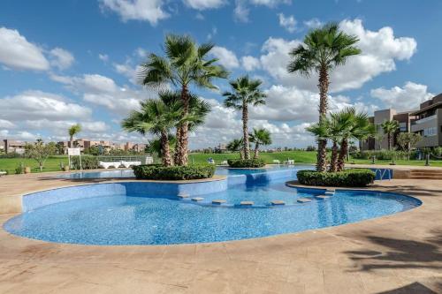 a swimming pool with palm trees in a park at Findy Golf City in Marrakesh