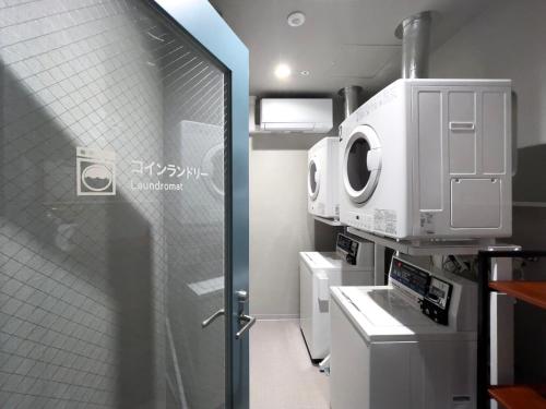 a bathroom with a shower and a washing machine at Super Hotel Premier Ikebukuro Natural Hot Spring in Tokyo