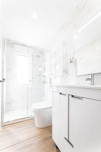 a white bathroom with a sink and a toilet at Apartamento Balbín II in Gijón