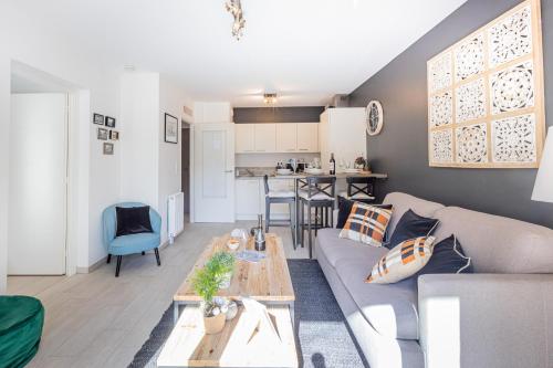 un salon avec un canapé et une table dans l'établissement La Clé Anglaise - WIFI - PARKING - Balcon, à Wimereux