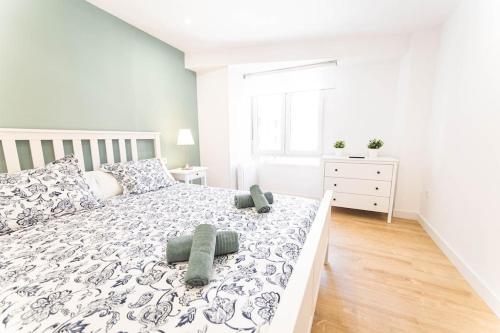 a white bedroom with a large bed with pillows at Apartamento Balbín II in Gijón