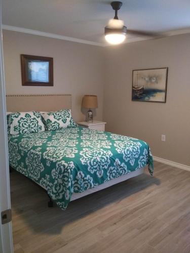 a bedroom with a bed with a green and white bedspread at Executive Keys Condominiums on the Beach in Port Aransas