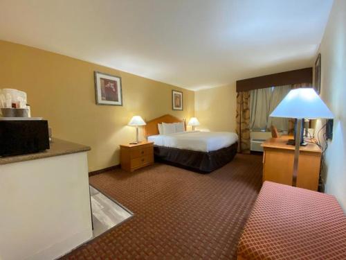 una camera d'albergo con letto e scrivania con lampada di Ocotillo Inn a El Centro