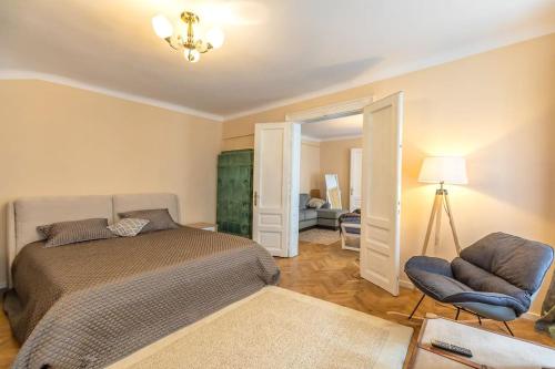 - une chambre avec un lit, une chaise et un miroir dans l'établissement StylishCozy Apartment, à Braşov