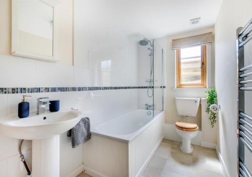 a white bathroom with a sink and a toilet at Caban Cwm Hedd in Bassaleg