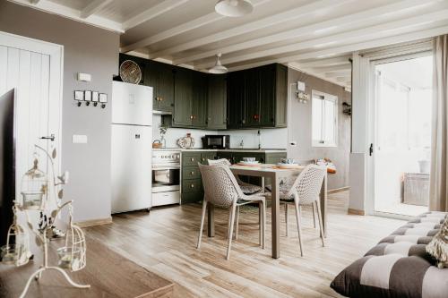 uma cozinha com armários verdes e uma mesa e cadeiras em Casa Lara, Las Maretas em Arico